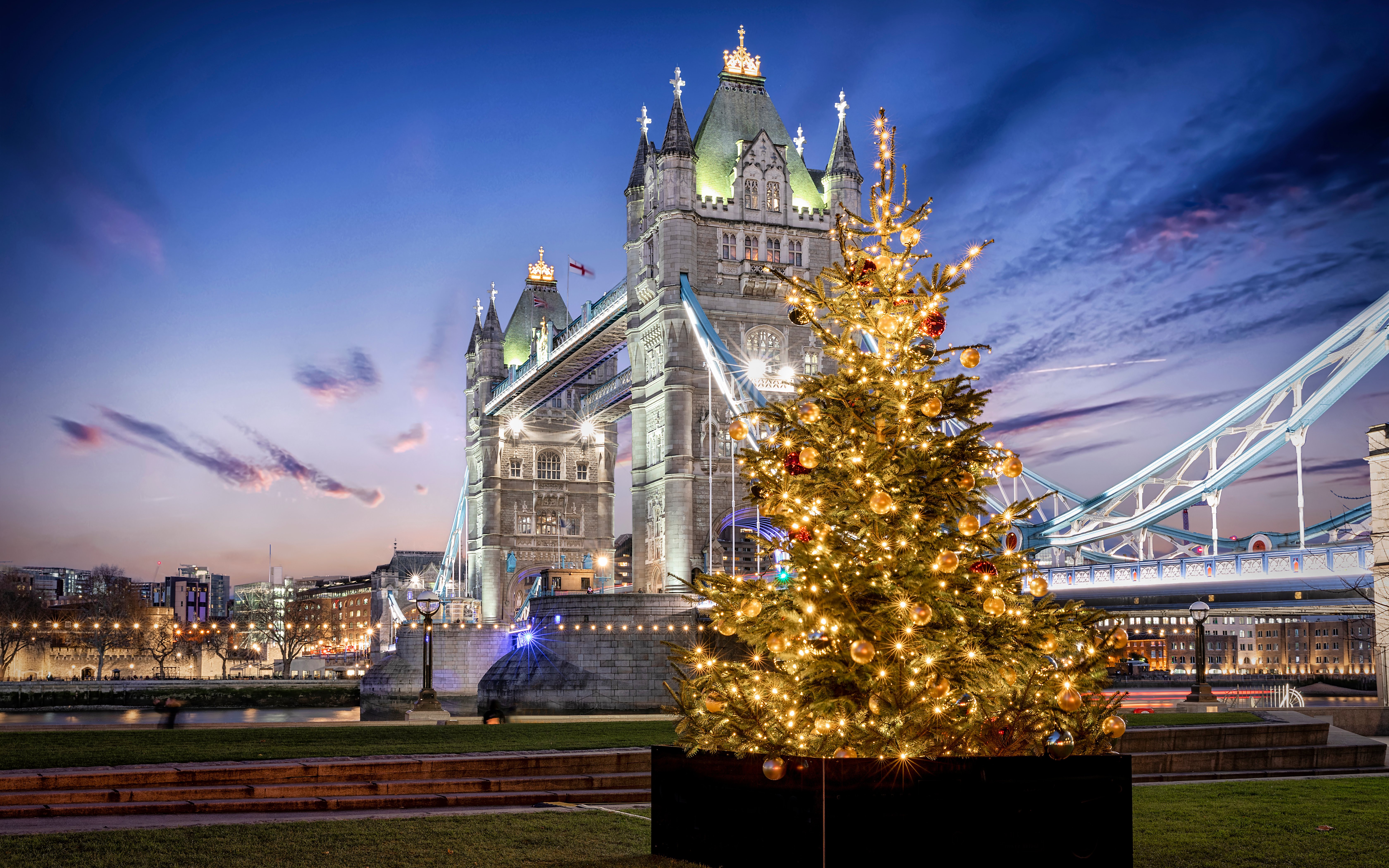 Tower Bridge in London with a decorated Christmas tree in the foreground.