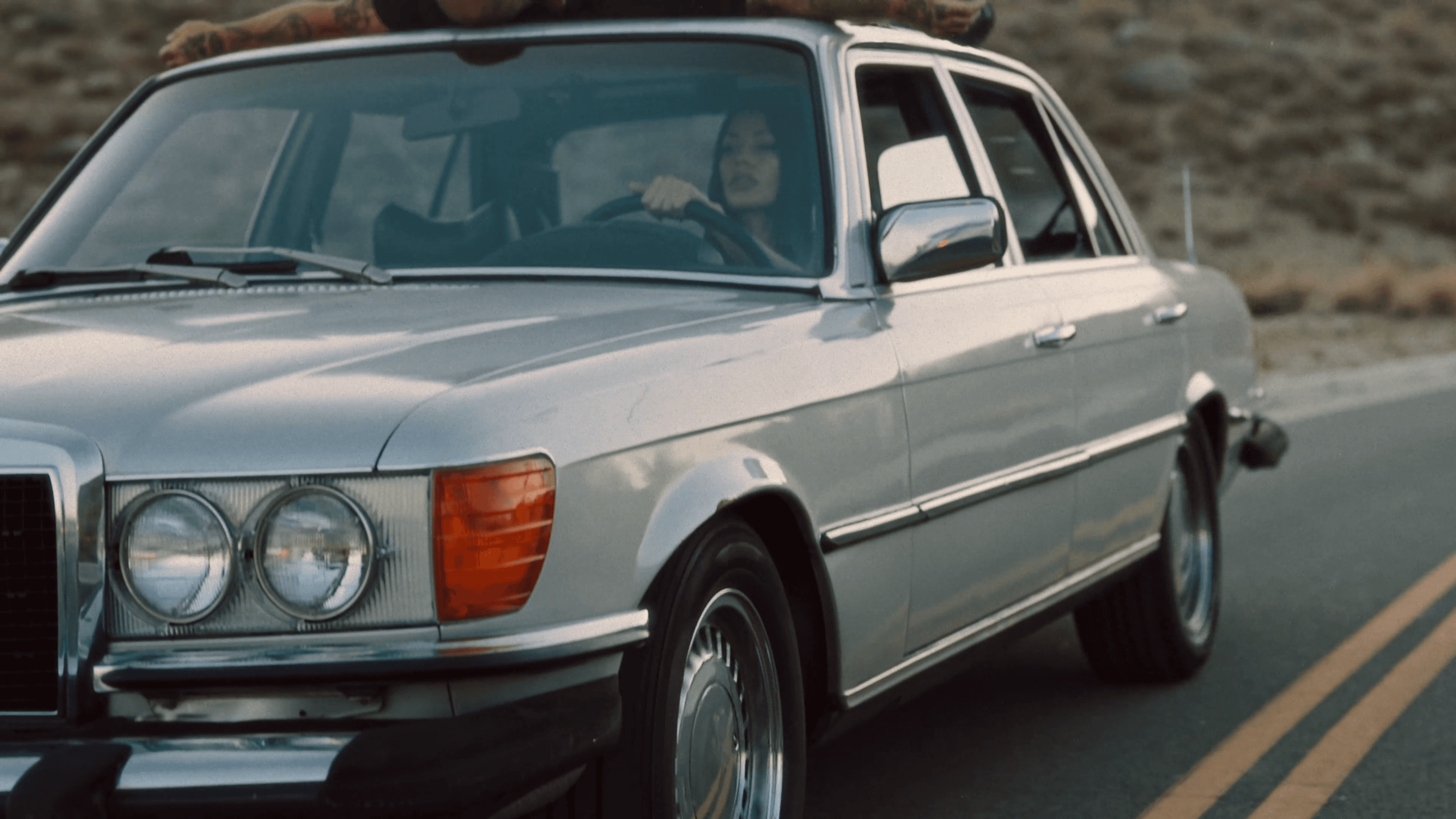 A person stands on a street corner at night.