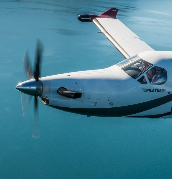 Closeup of pilots flying the PIlatus PC-12 over lake