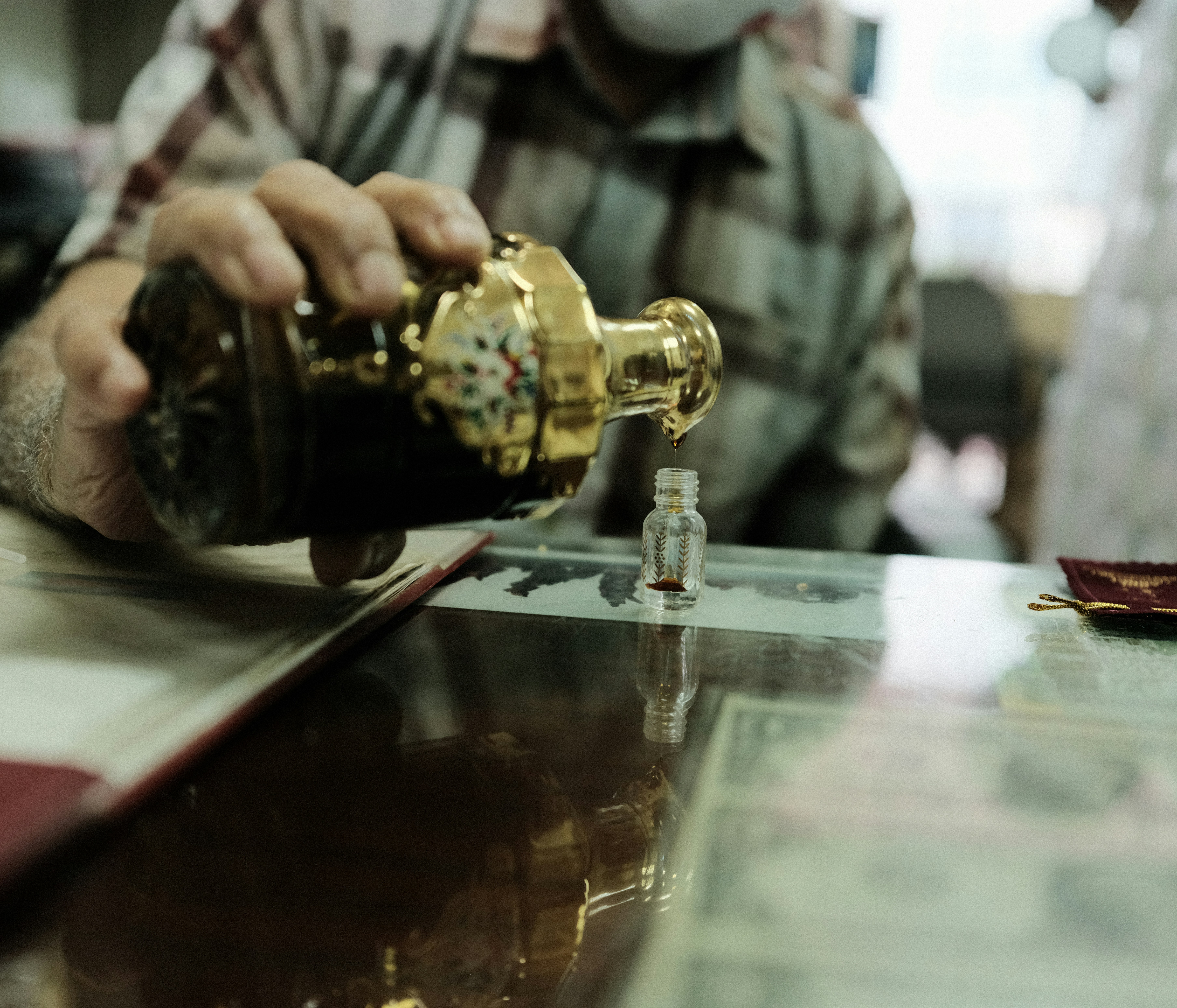 Visual of a man carefully blending perfume ingredients into a small bottle, capturing craftsmanship behind the brand’s product narrative