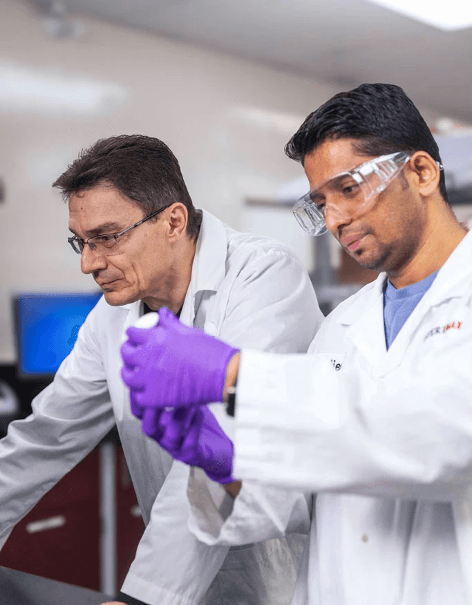 Two SteriMax scientists working together to examine a pharmaceutical sample in a laboratory.