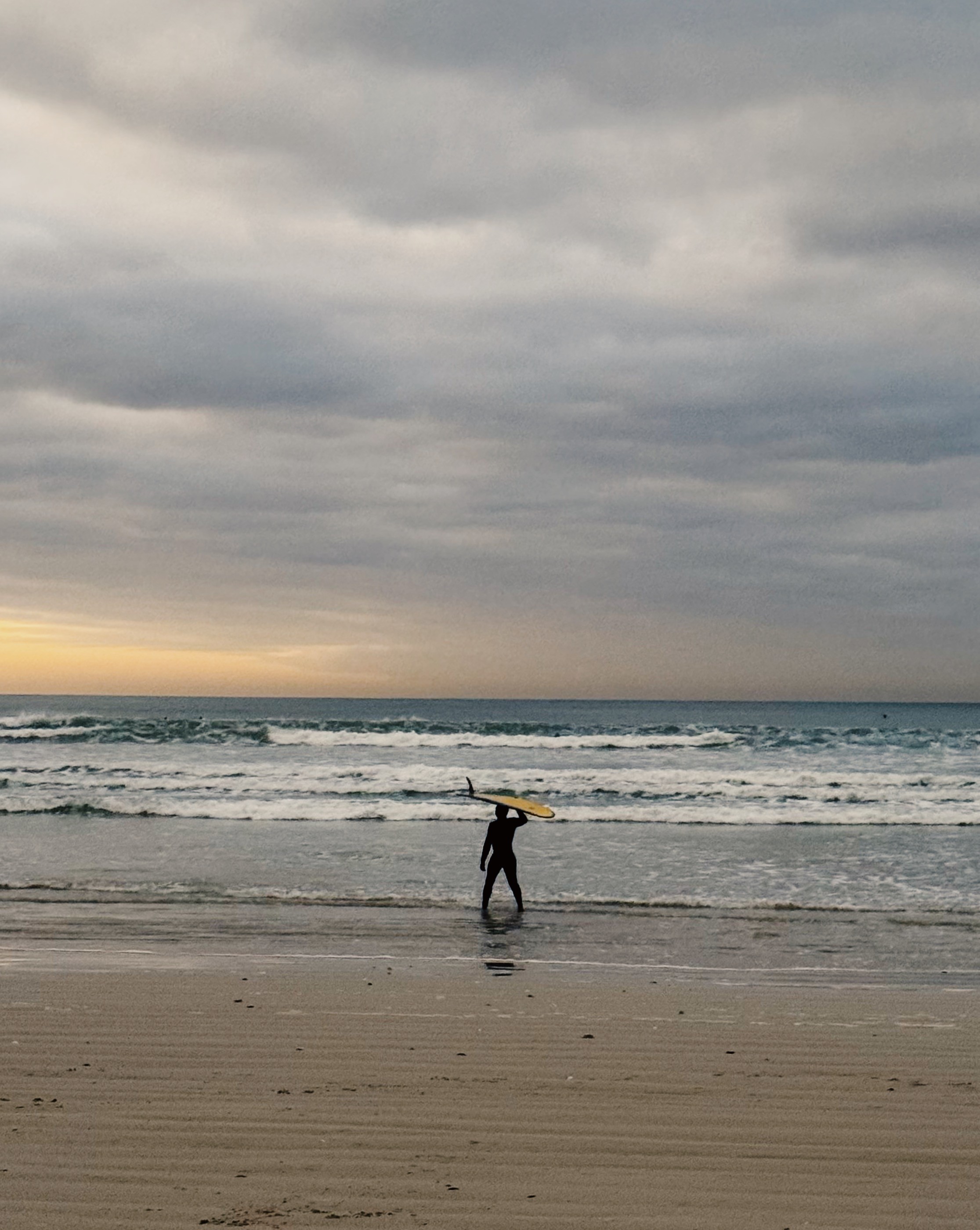 A man stading with Surfboard