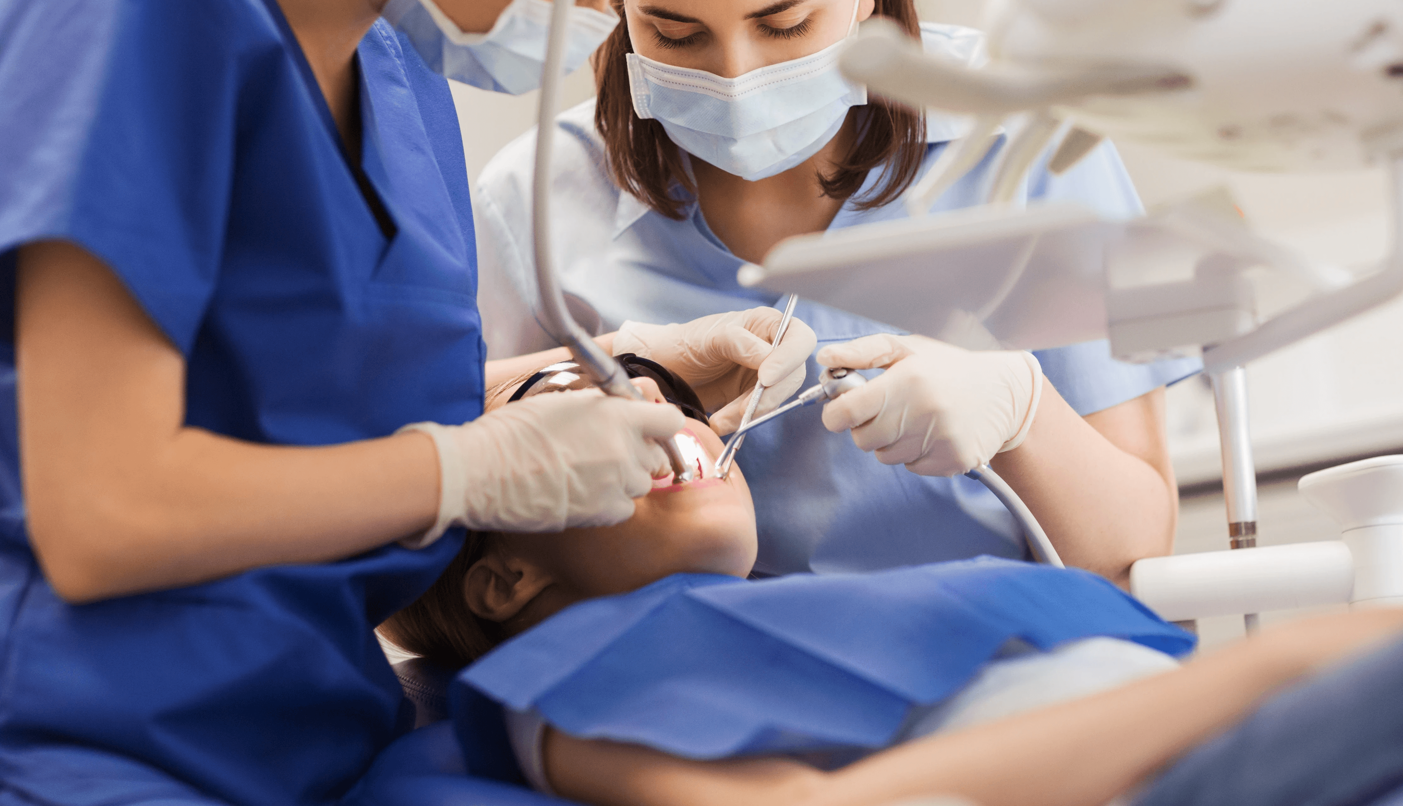 Smiling woman using a rose quartz Gua Sha stone and face roller for a facial massage
