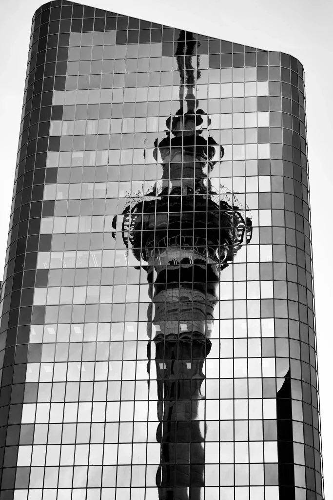 Reflection of the Auckland Sky Tower in a glass building in Auckland, New Zealand, a major private jet charter destination