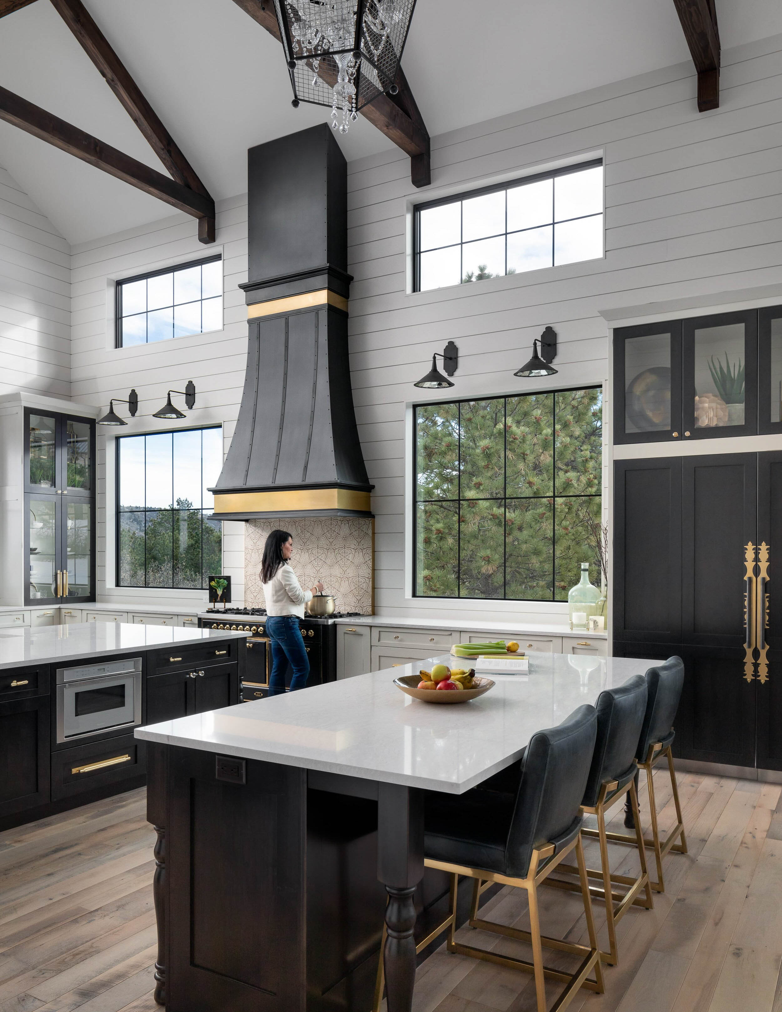 Luxury modern kitchen with black cabinetry and large windows.