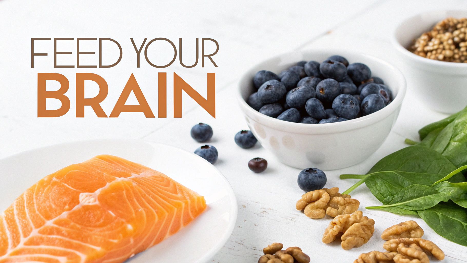 Brain-boosting foods including fresh salmon, blueberries, walnuts, and spinach arranged on white surface