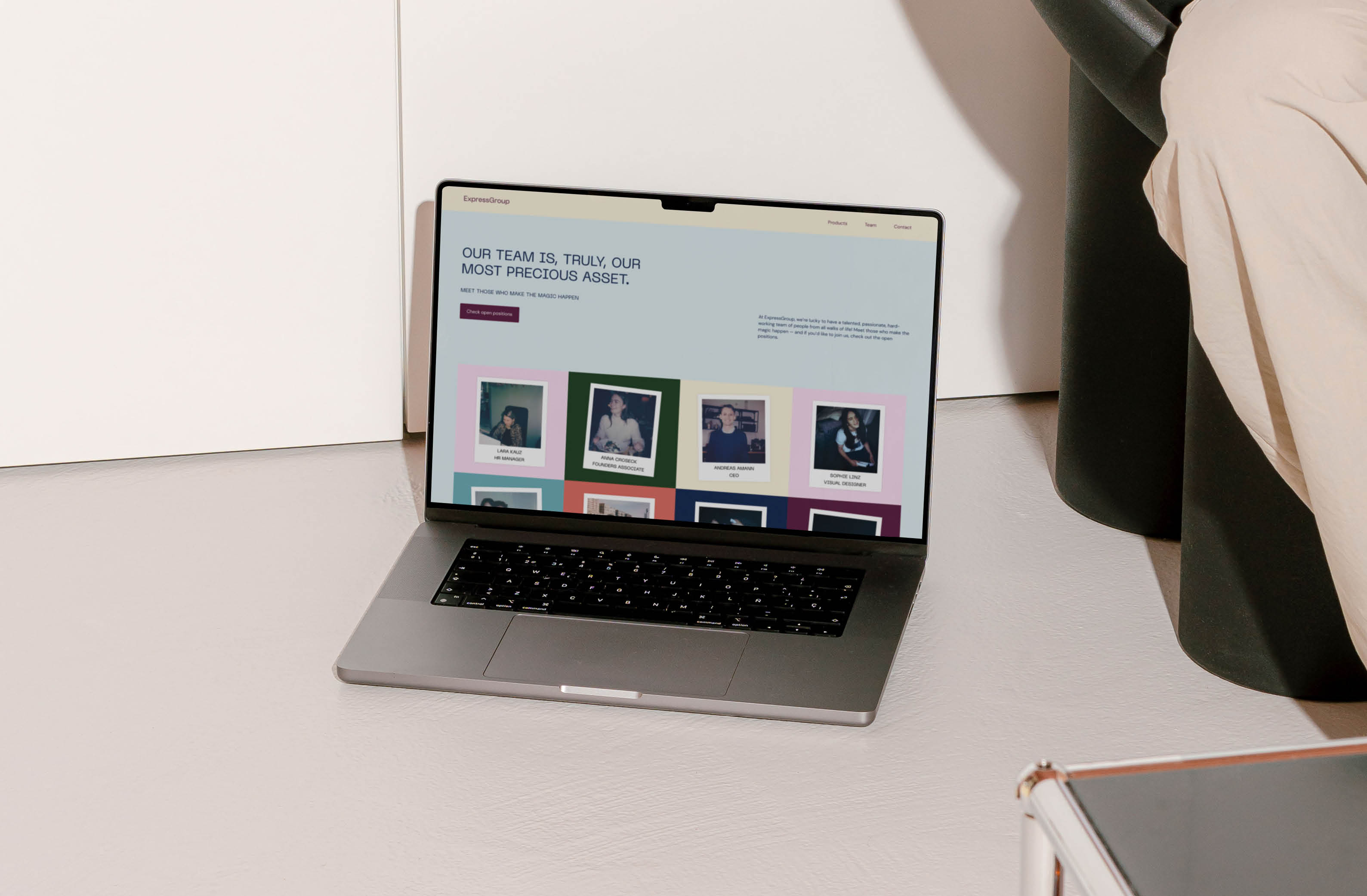 MacBook displaying ExpressGroup team webpage with employee photos in colorful frames.
