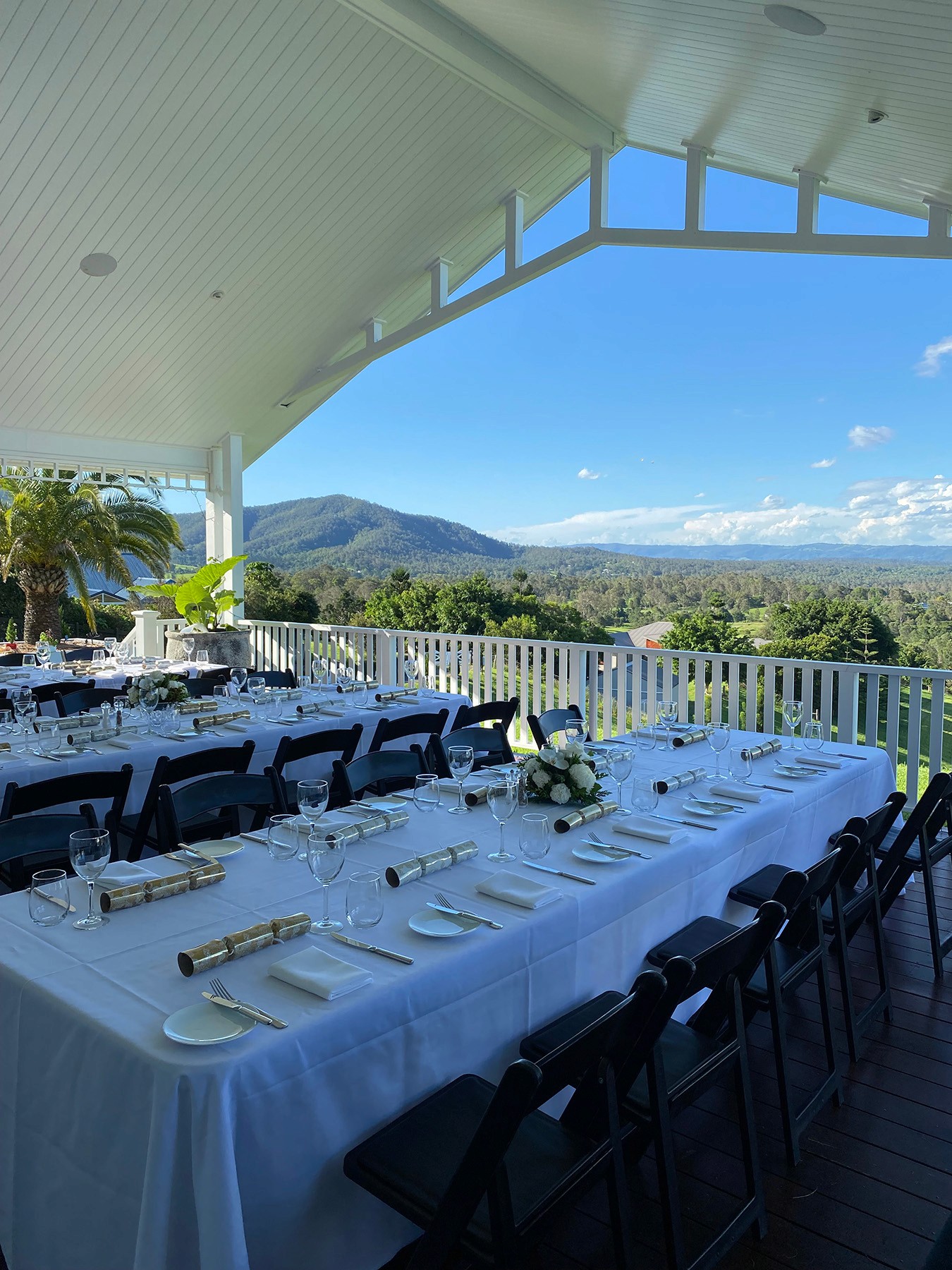 Tables set up on the balcony of a private home, overlooking the hinterland