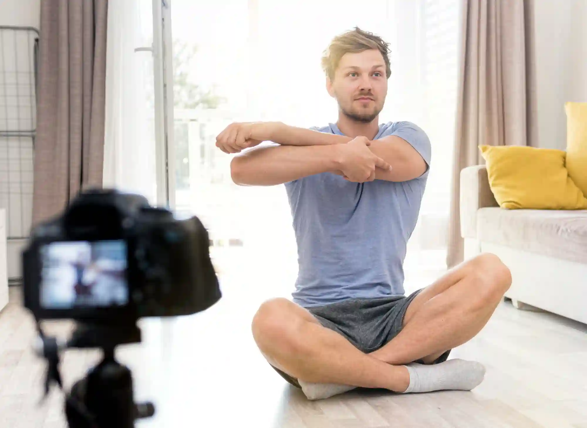 Man recording a home workout or fitness video on camera.