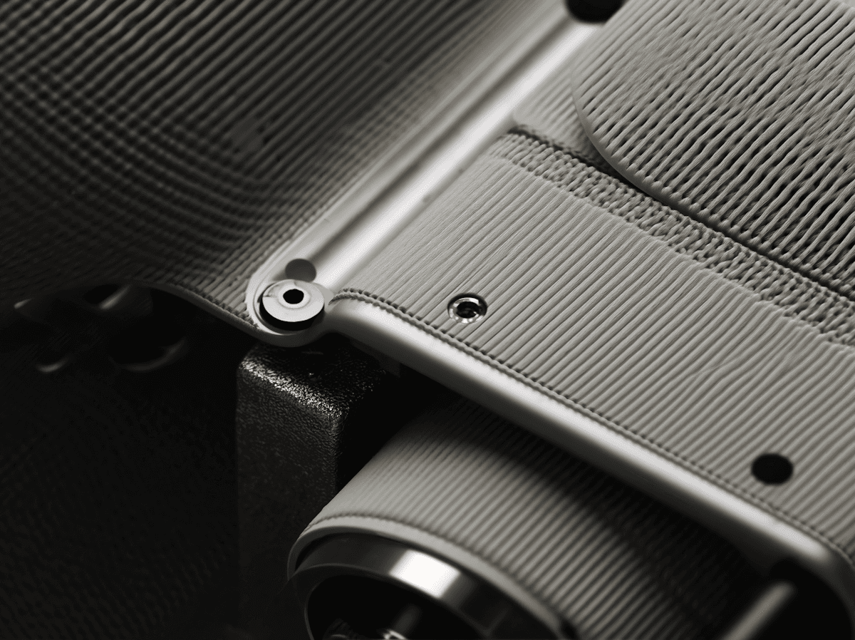 Smartphone held by a mechanical clamp showing the RMFORM mobile portfolio website.