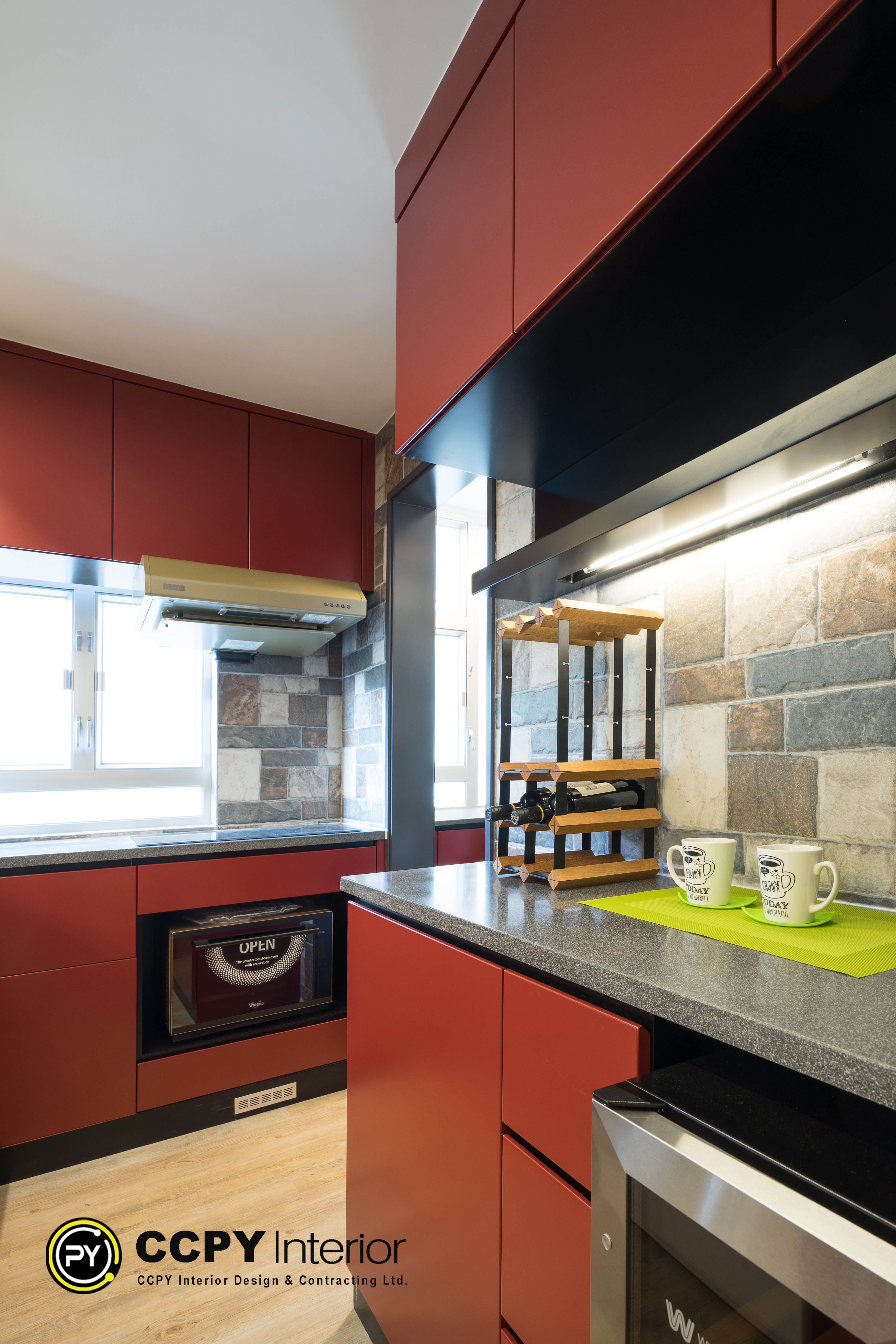 This is a modern kitchen featuring red cabinets and a stone-textured backsplash in ccpy interior