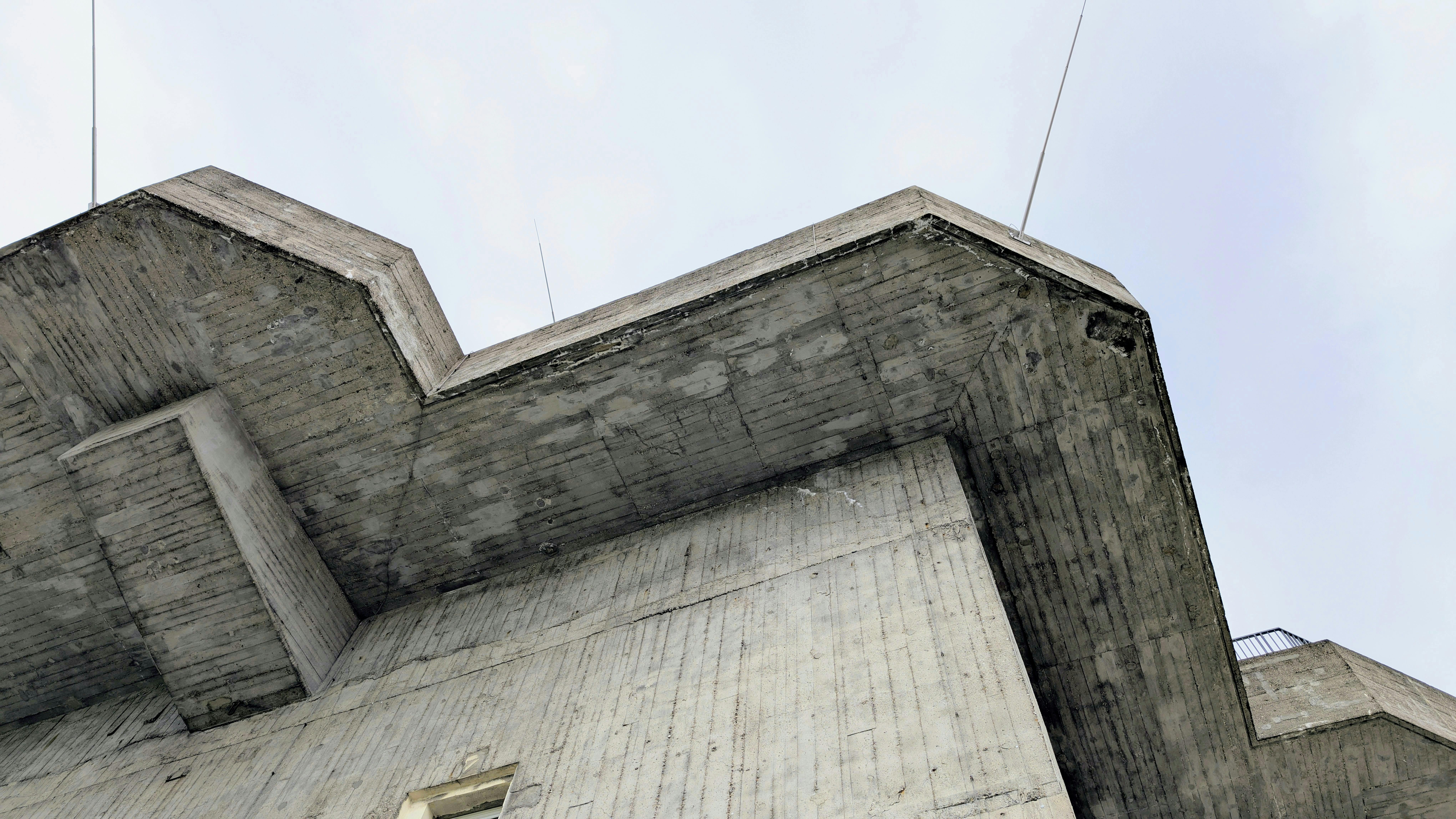 Female lab technician in protective gear using a high-tech analyzer while referencing data on dual computer screens in a laboratory setting.