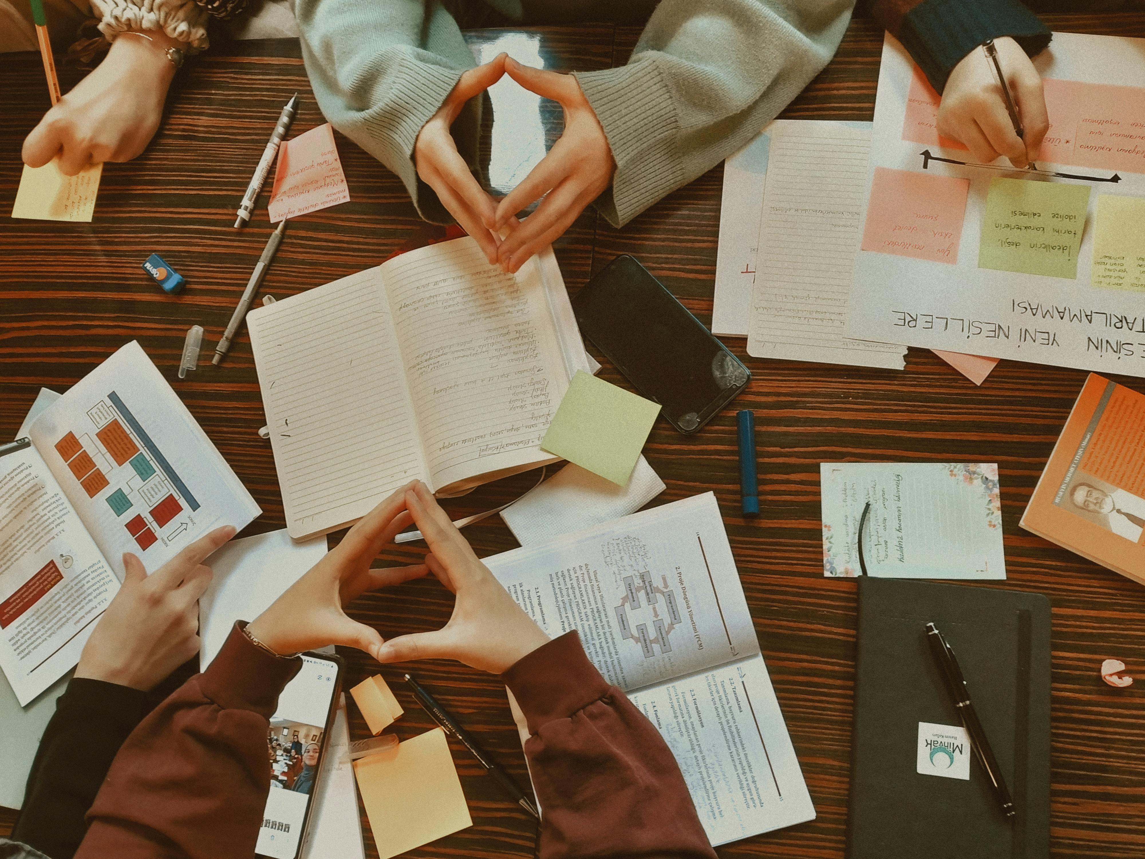 Hands of a Group of Students Studying Together around a Table