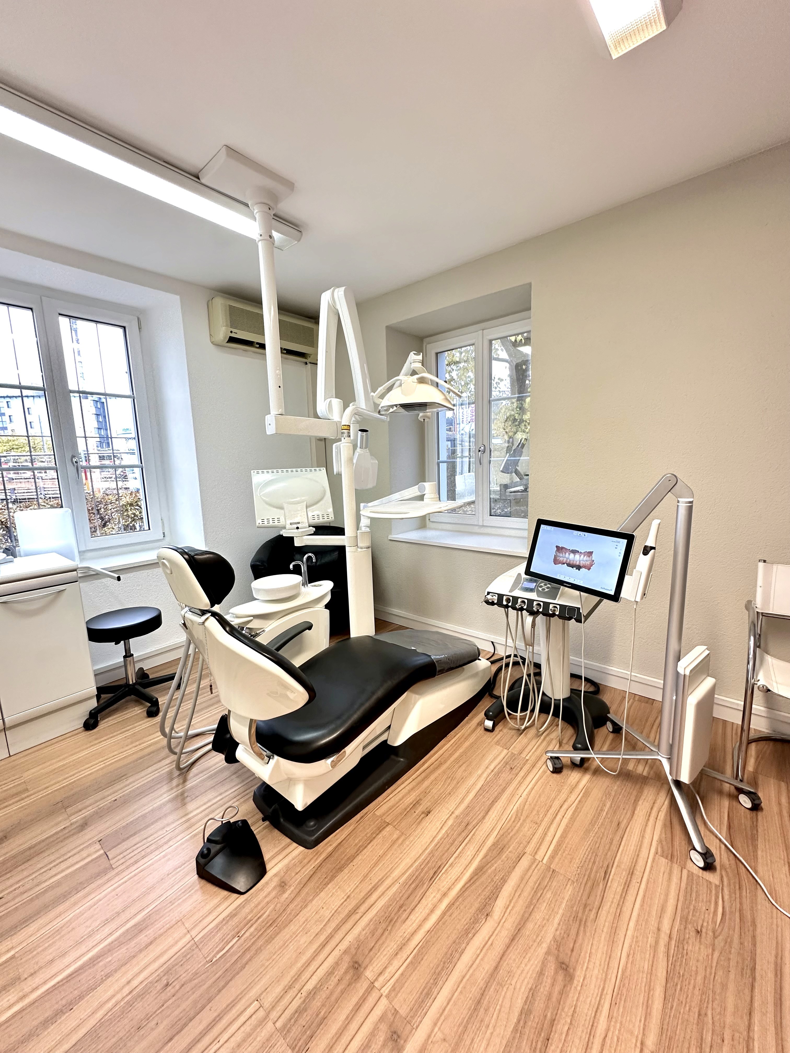 Behandlungsraum mit hochwertiger Zahnmedizin-Ausstattung und Holzfußboden.