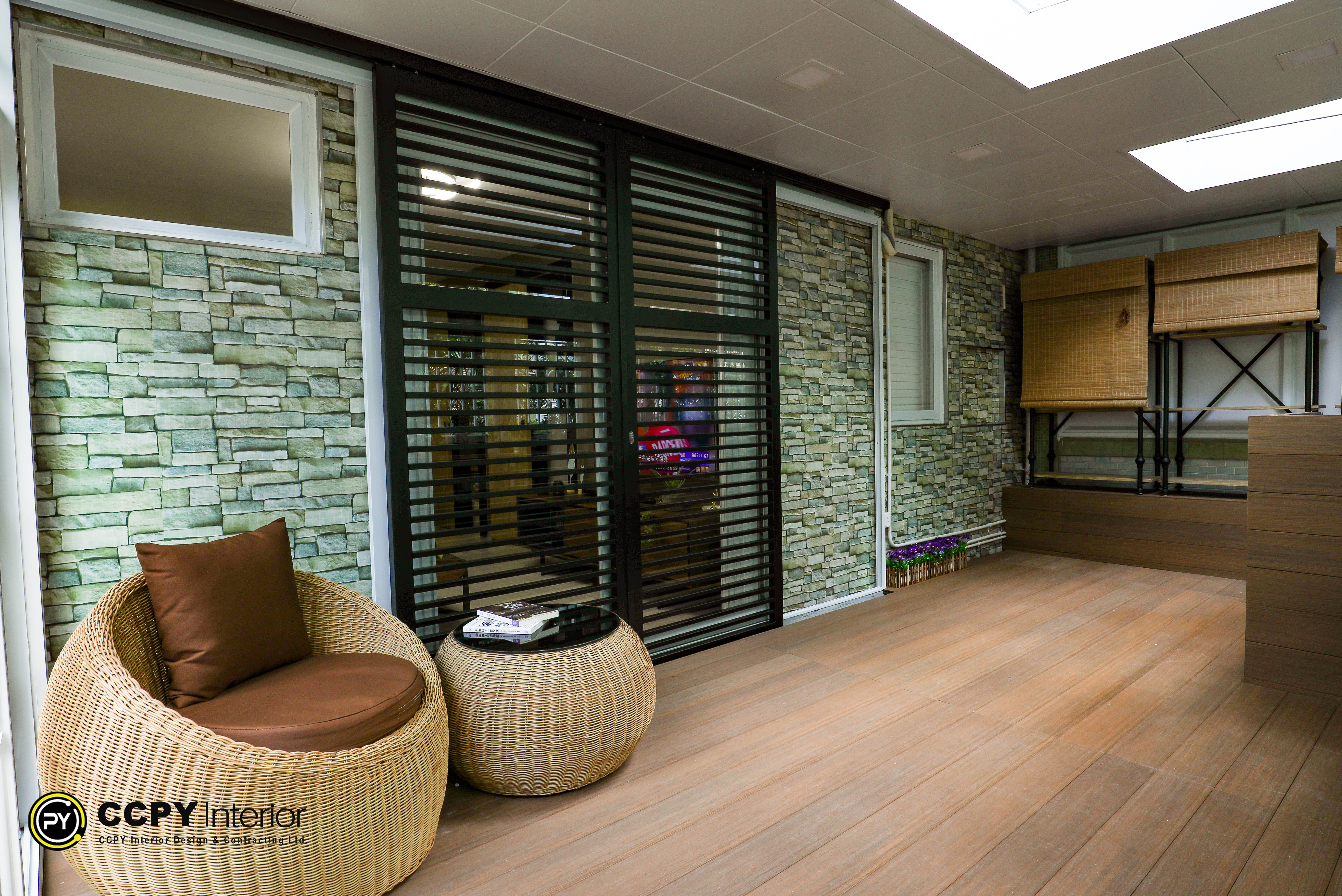 Sunroom lounge with shelving unit, sneakers, potted plants, and ample natural light from large windows at Kwan Lok Sun Chuen.
