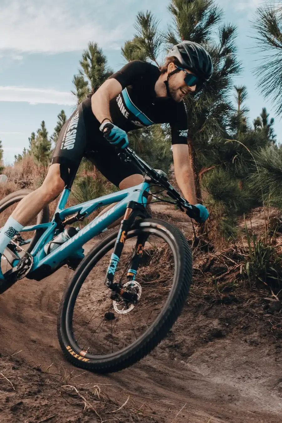 A man riding a bicycle through a froest pump track
