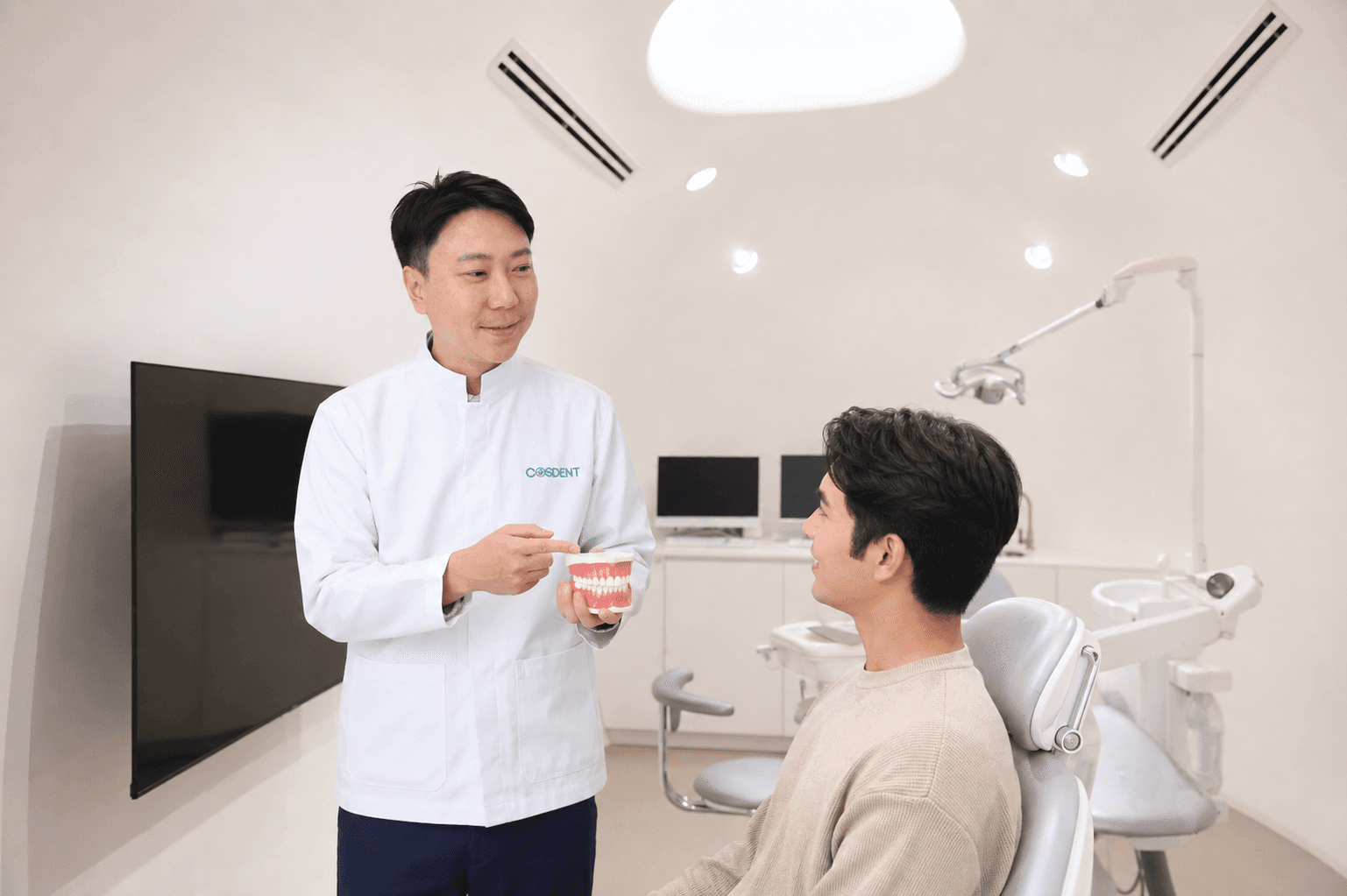Dr. Daniel discussing gum health with a patient at COSDENT Siam Square One (AI-generated illustrative composite)