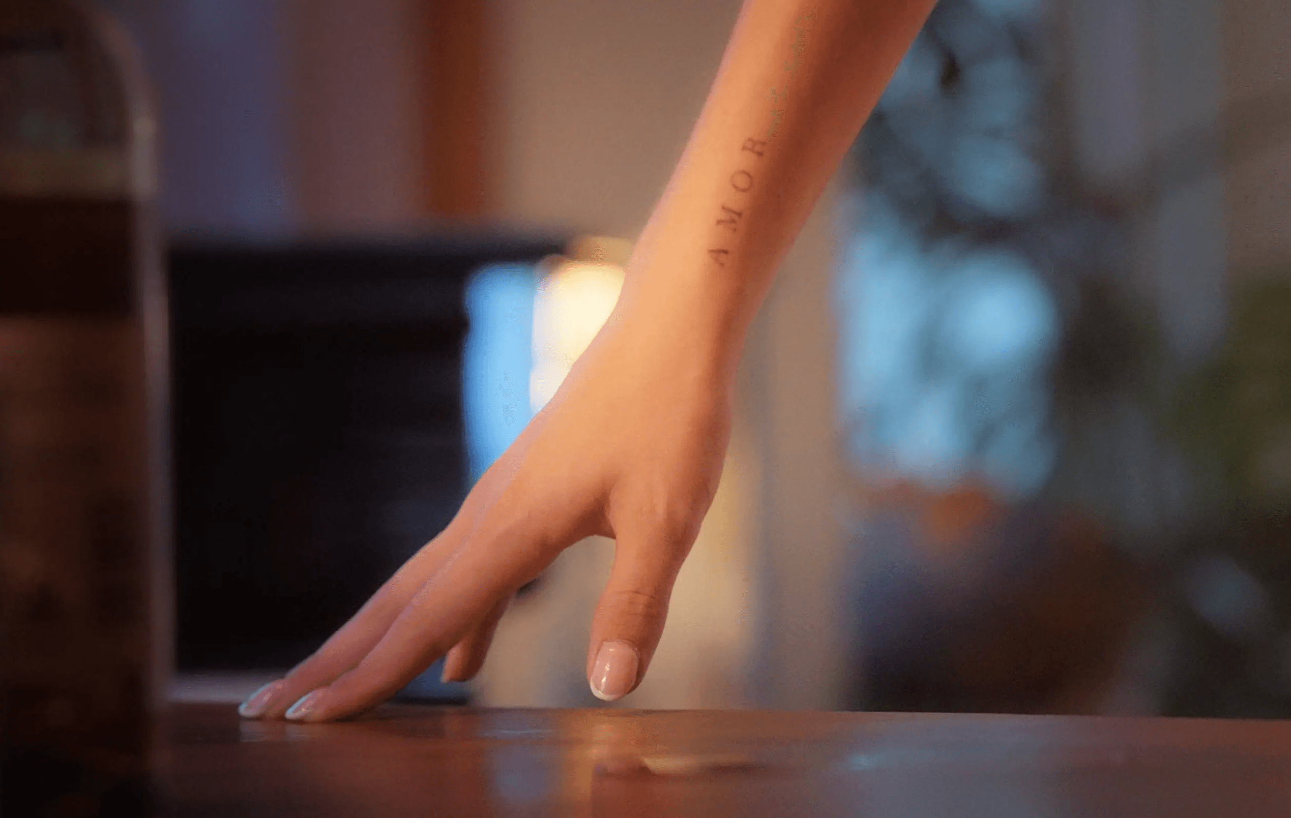 A close-up of a hand reaching towards a surface.