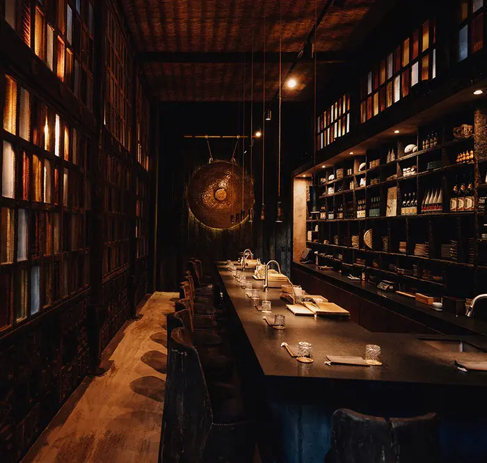 Long bar and chairs in luxurious and sophisticated Japanese restaurant called Kuu at Nômade Tulum, Mexico.