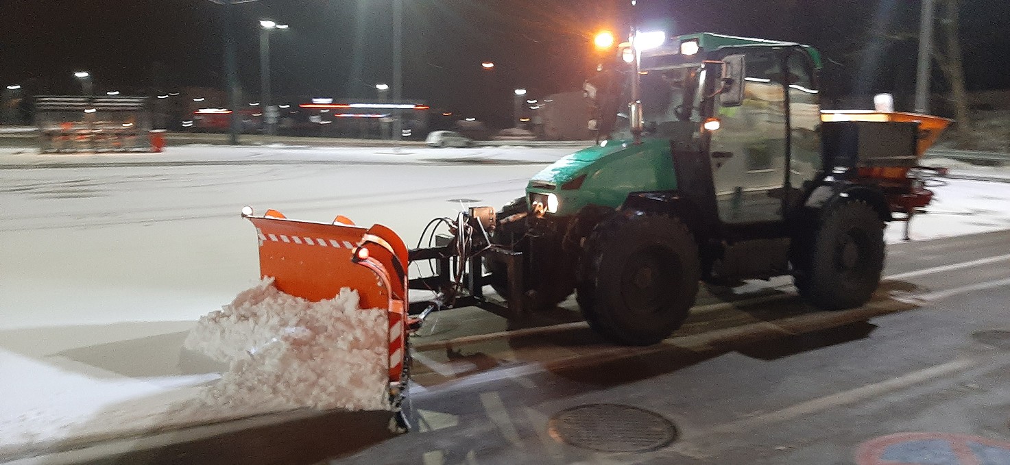 Nocne odśnieżanie parkingu traktorem