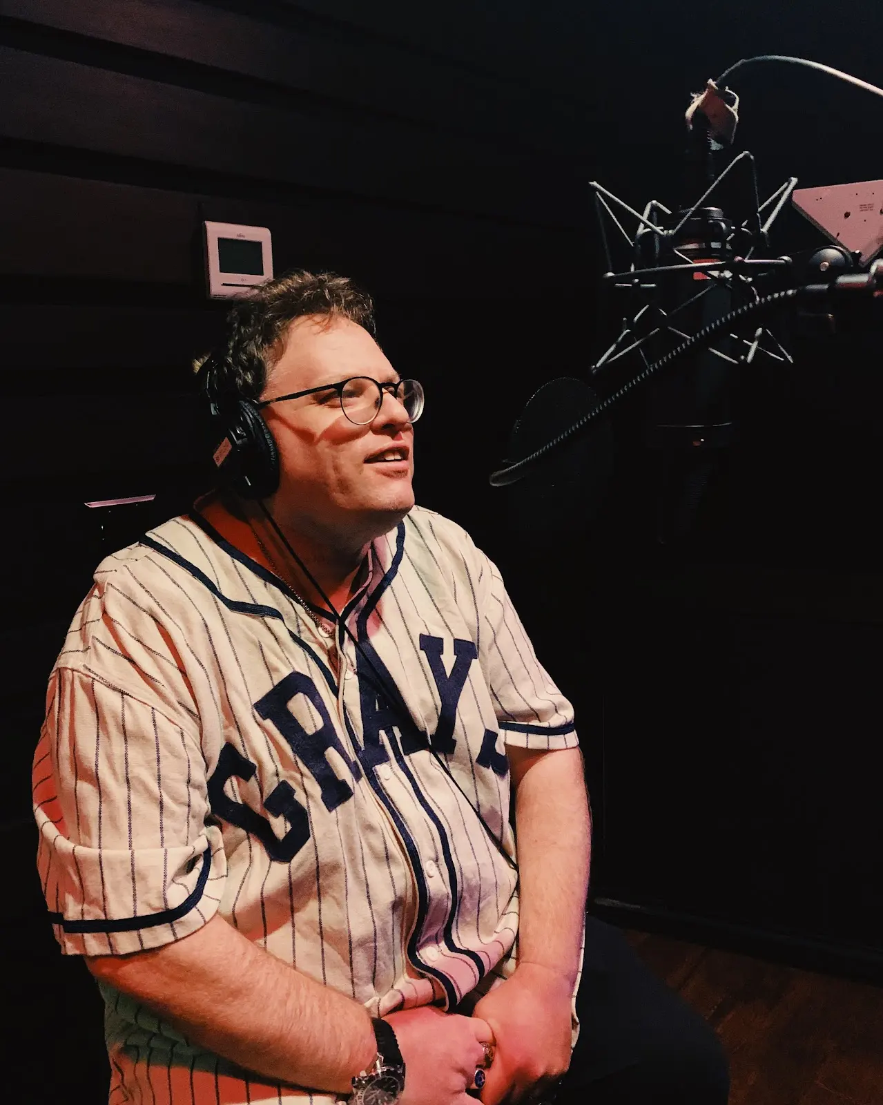 Host recording voiceover at the mic