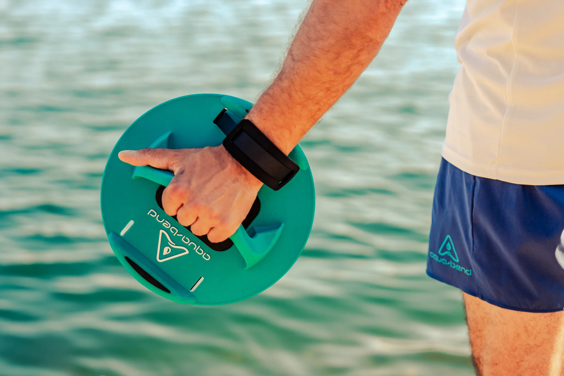 Close-up of hand gripping Aqua-Bend FIT disc in aqua green using overhand grip