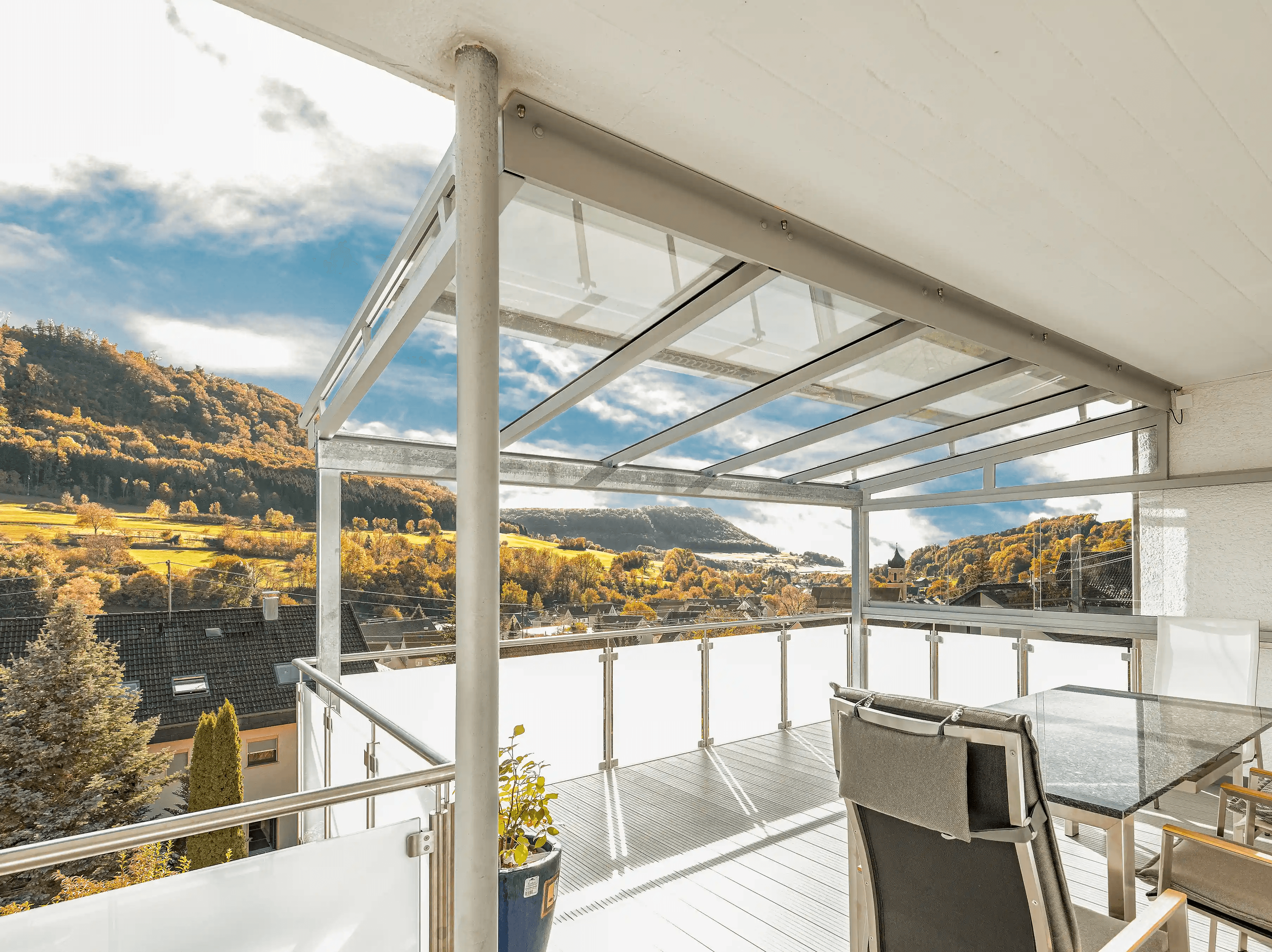 Terrassenüberdachung auf Balkon mit Glasgeländer als Panoramaaufnahme mit schönem Ausschau