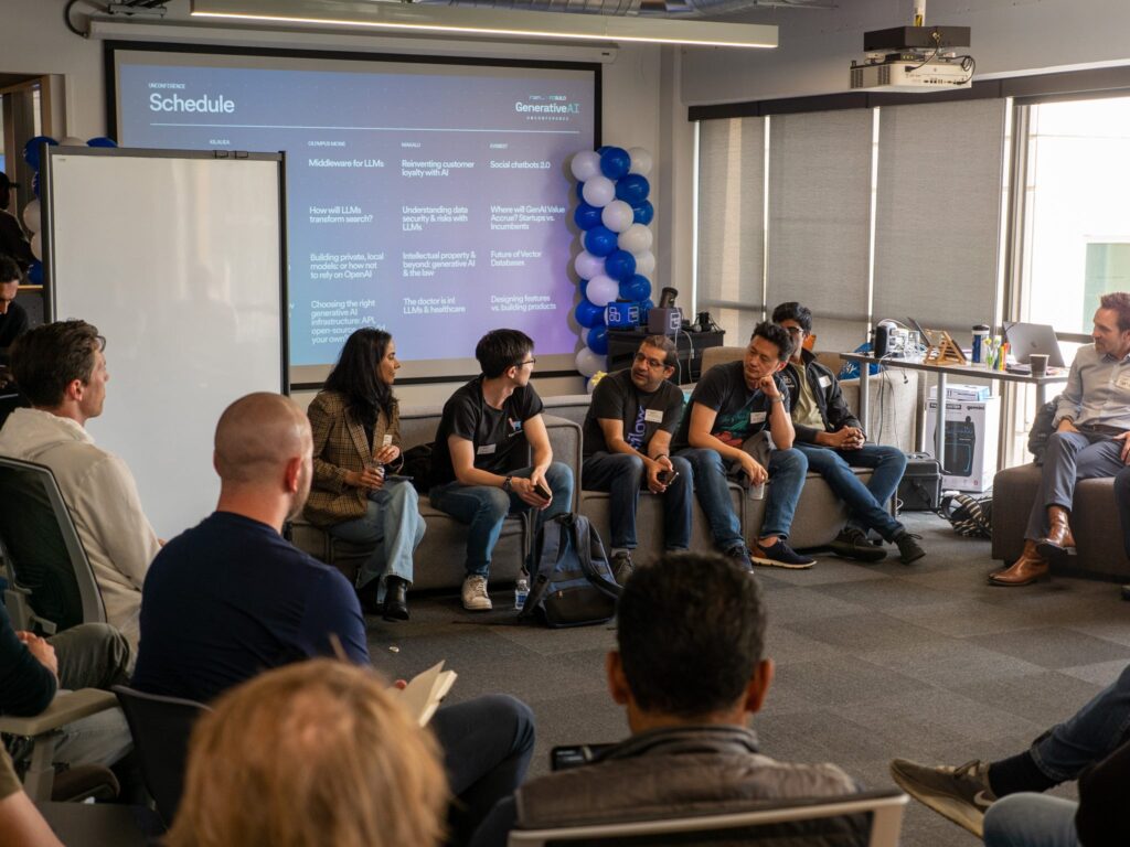 a group of people at the FC build conference sitting infront of a projector with the unconference schedule behind them