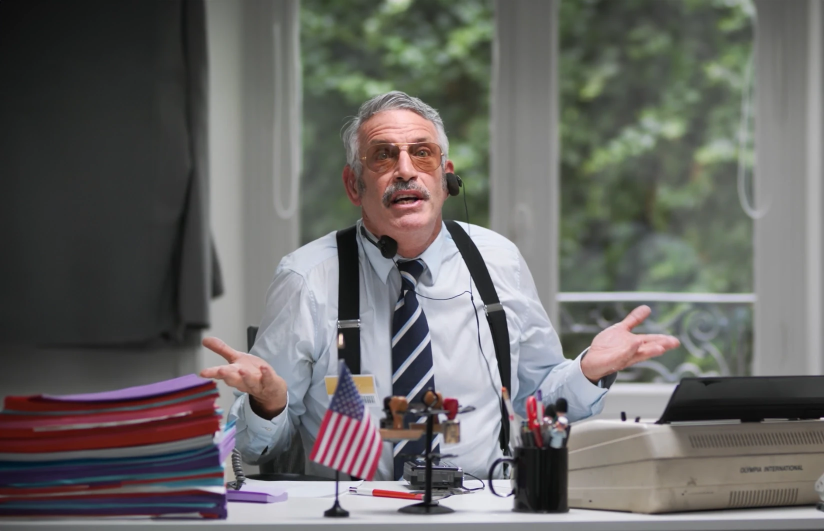 Portrait de l'acteur Ken Samuels incarnant un manager débordé pour une campagne Opcalia, illustrant notre expertise en "Production audiovisuelle" et en humour pour promouvoir la formation professionnelle de manière décalée