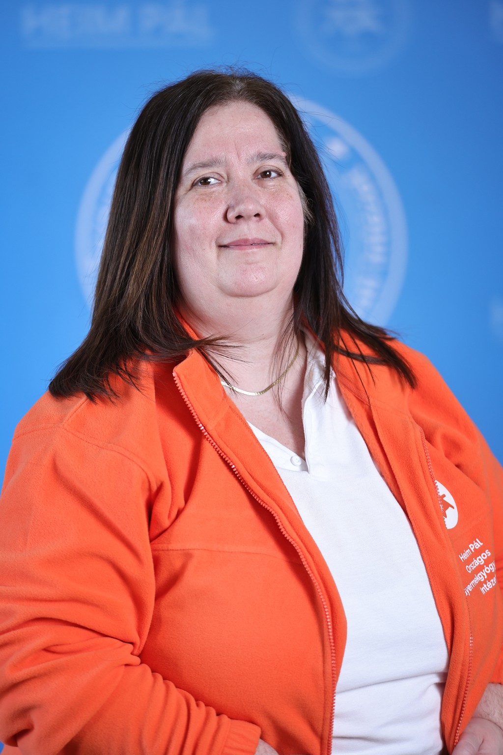 Sötéthajű nő narancssárga kardigánban