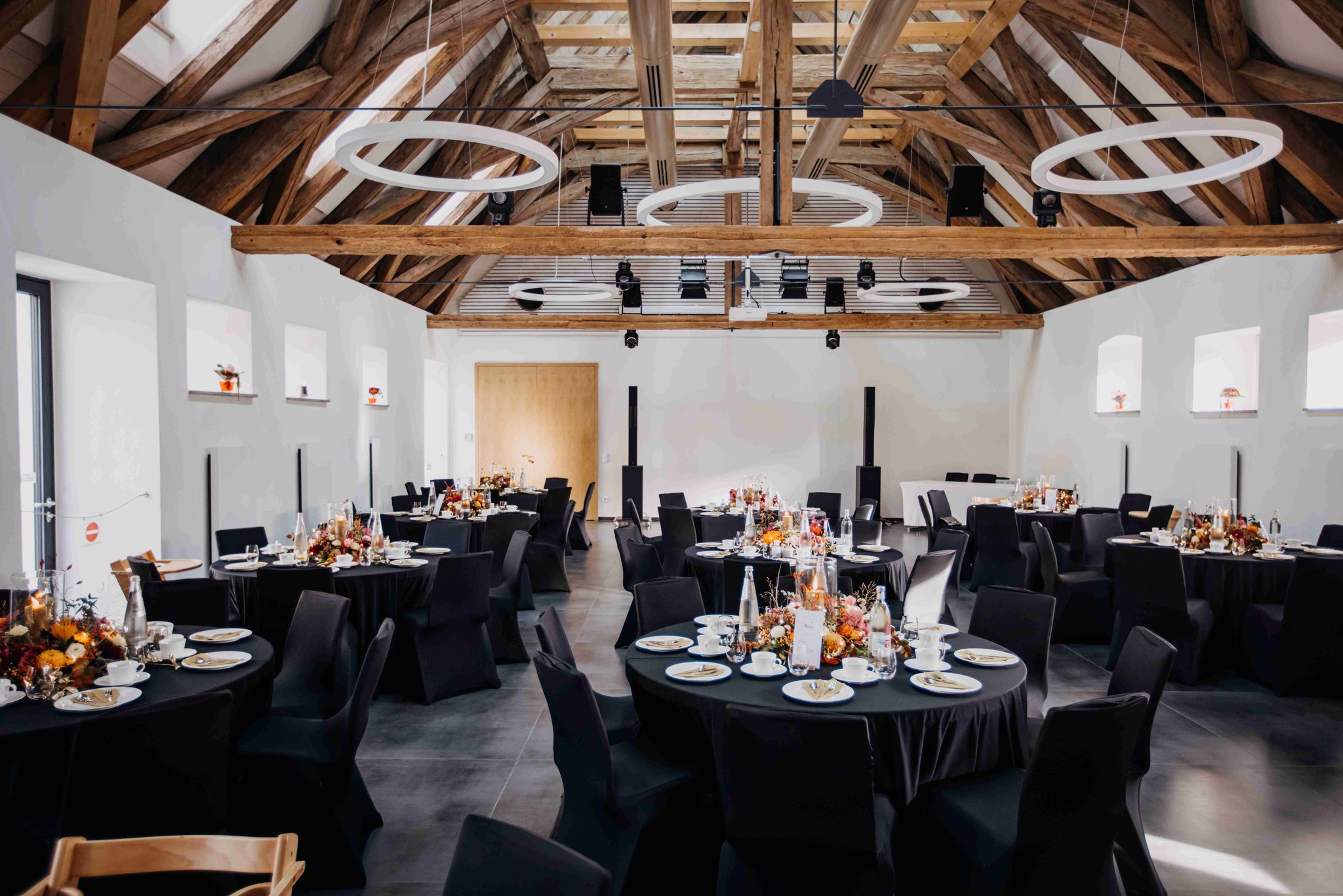 Moderne Hochzeitsfeier im Schafhof Wiesentheid mit runden Tischen und eleganter Bestuhlung.