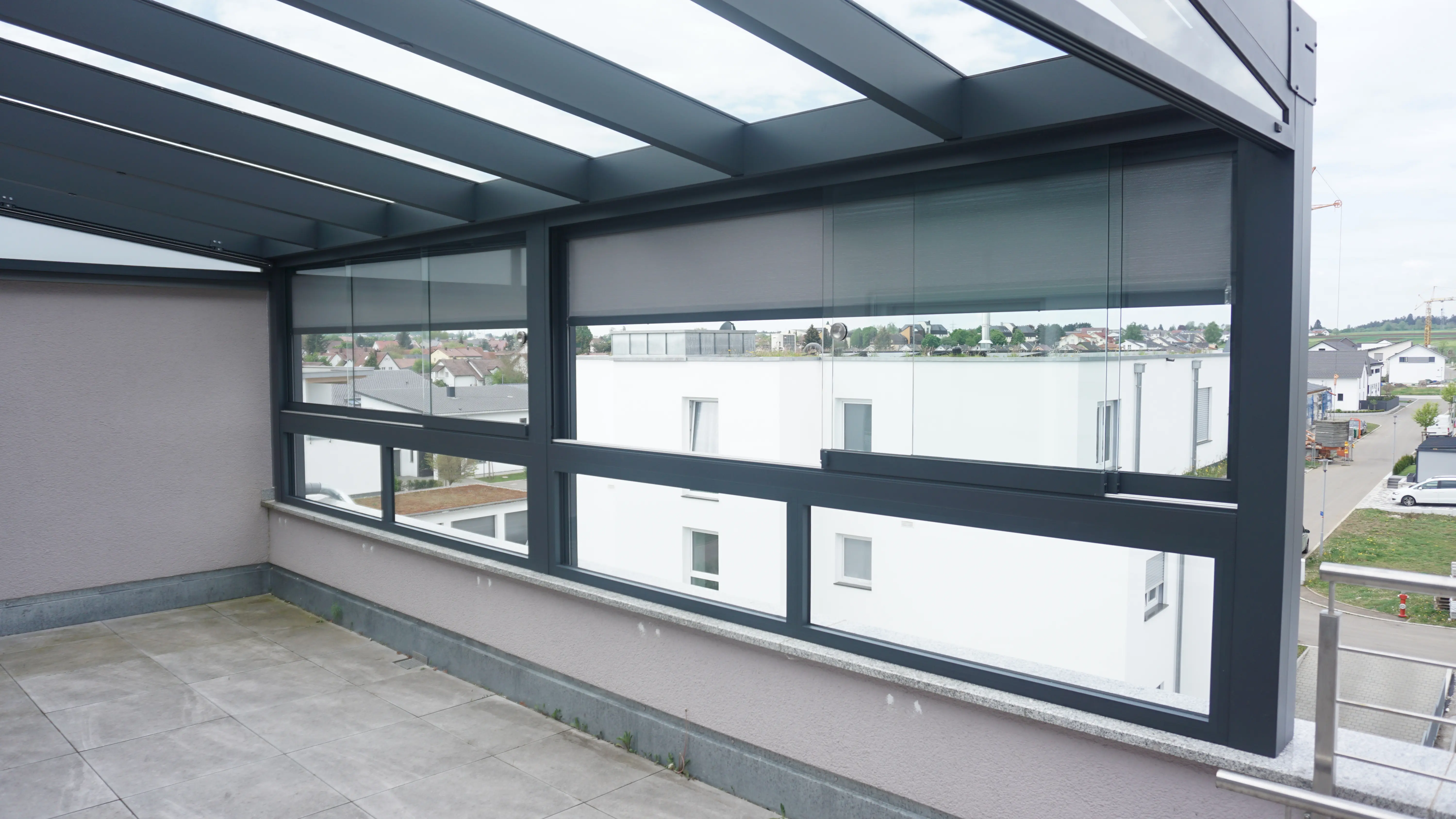 Terrassenverglasung mit Schiebeelementen und Glasdach auf einer Dachterrasse