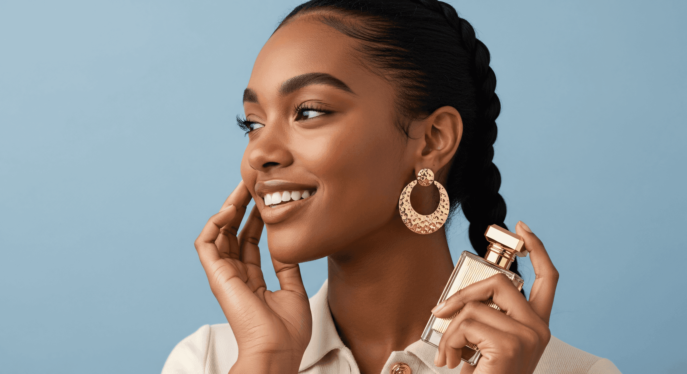 A model holding a perfume looking sideways