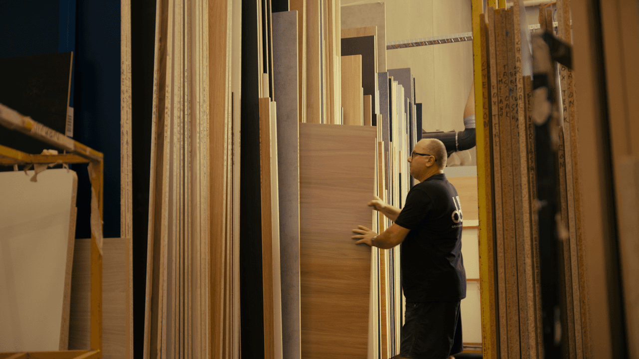 Person standing in a narrow aisle between tall shelves