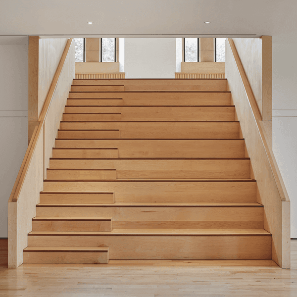 Furniture and interior design and build for a hardwood staircase with integrated seating in an old converted church building