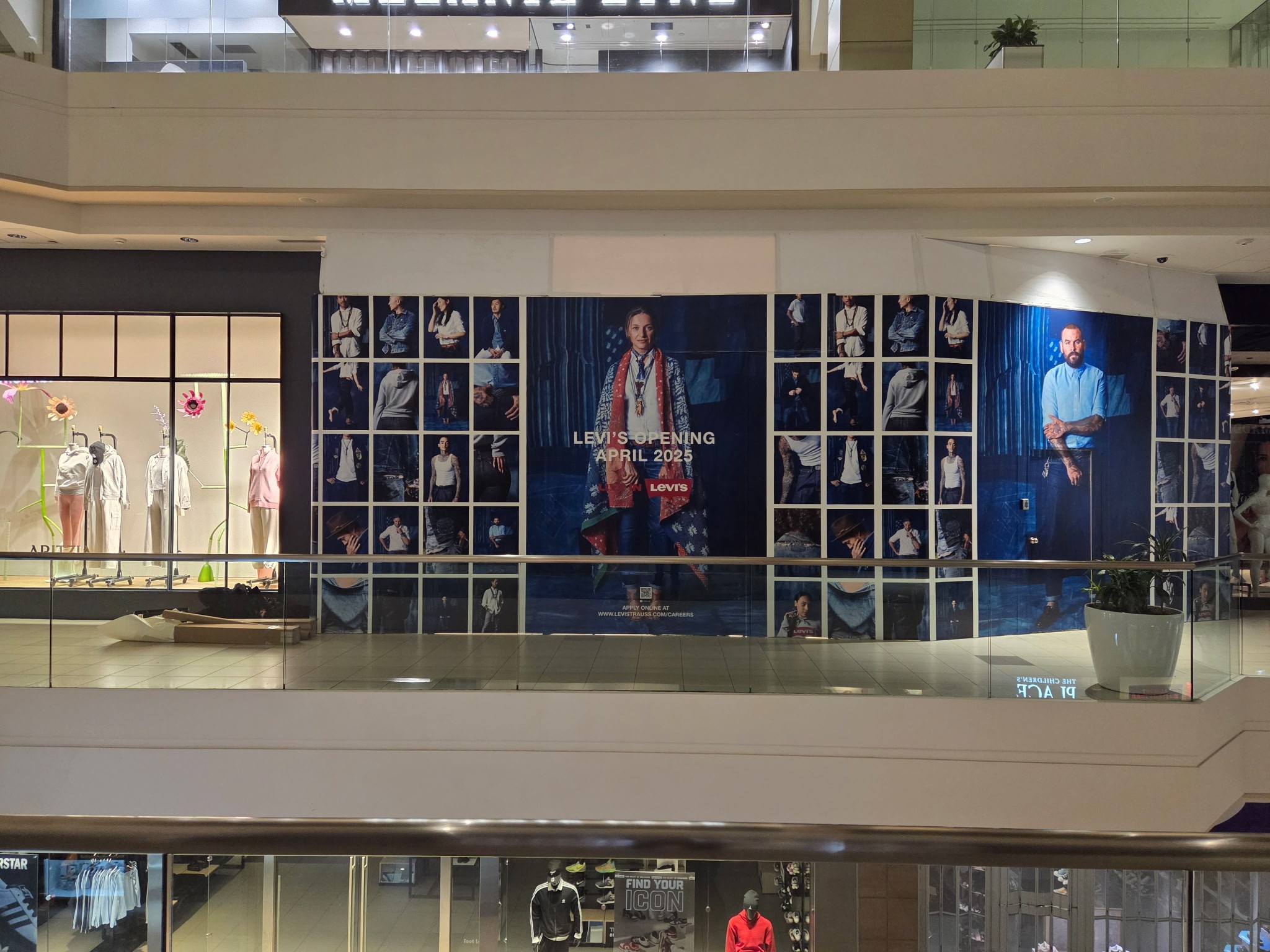Large-scale Levi’s retail wall graphics installed inside a shopping mall, featuring fashion imagery and branded promotional messaging.
