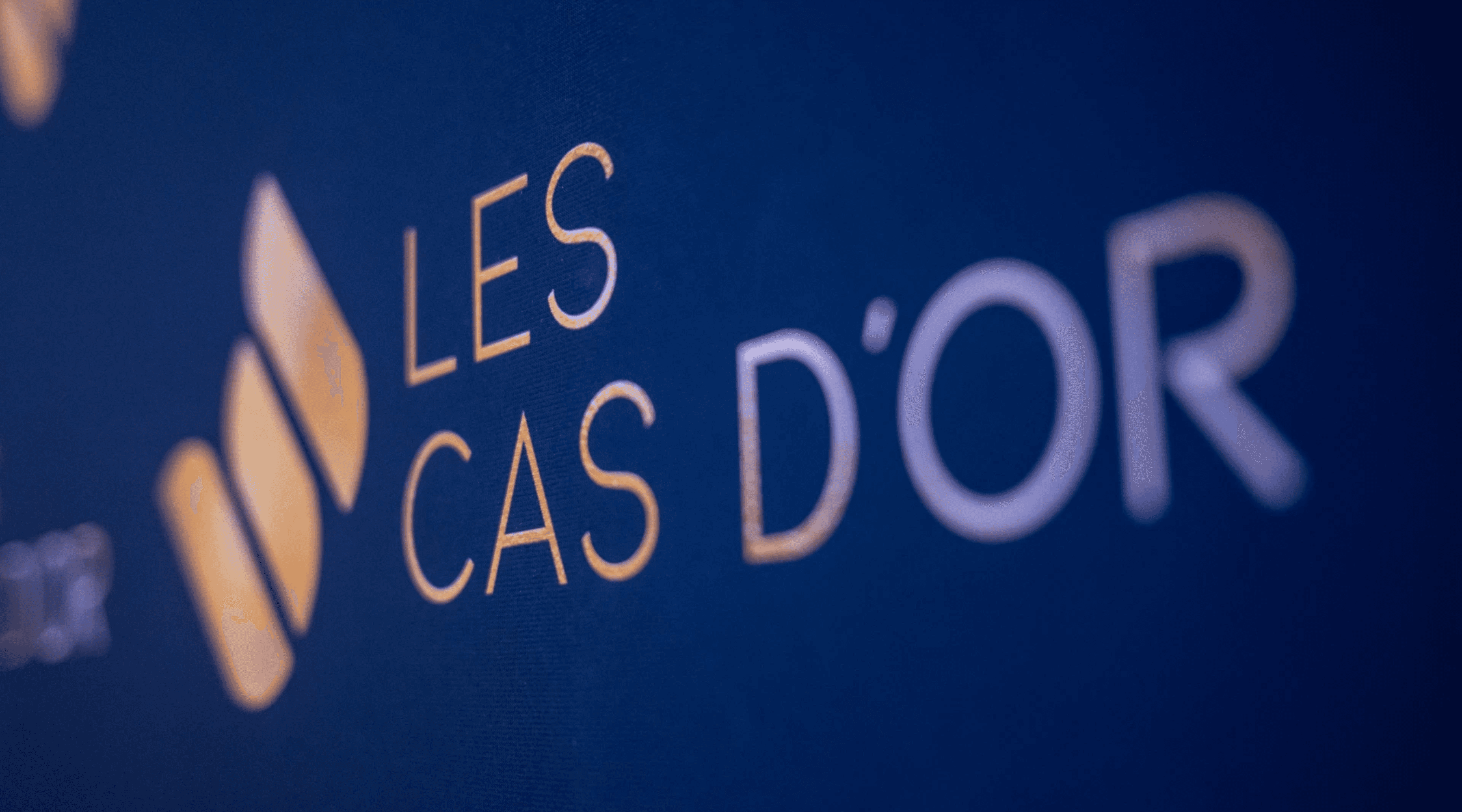 Black patent leather shoes and wide-leg pants stand on a deep red carpet, conveying a sense of elegance and sophistication.