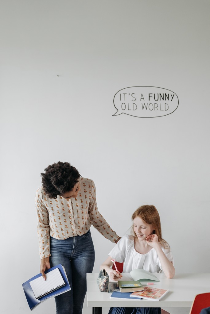 Schulbegleiterin mit Kind auf dem Schulhof einer Grundschule im Havelland