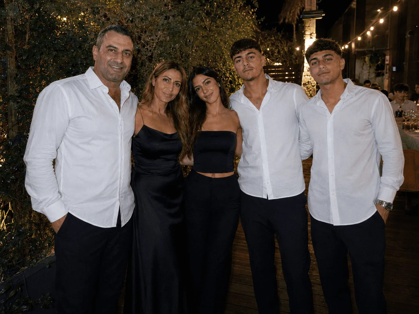 משפחה מצטלמת יחד באירוע חגיגי בחוץ