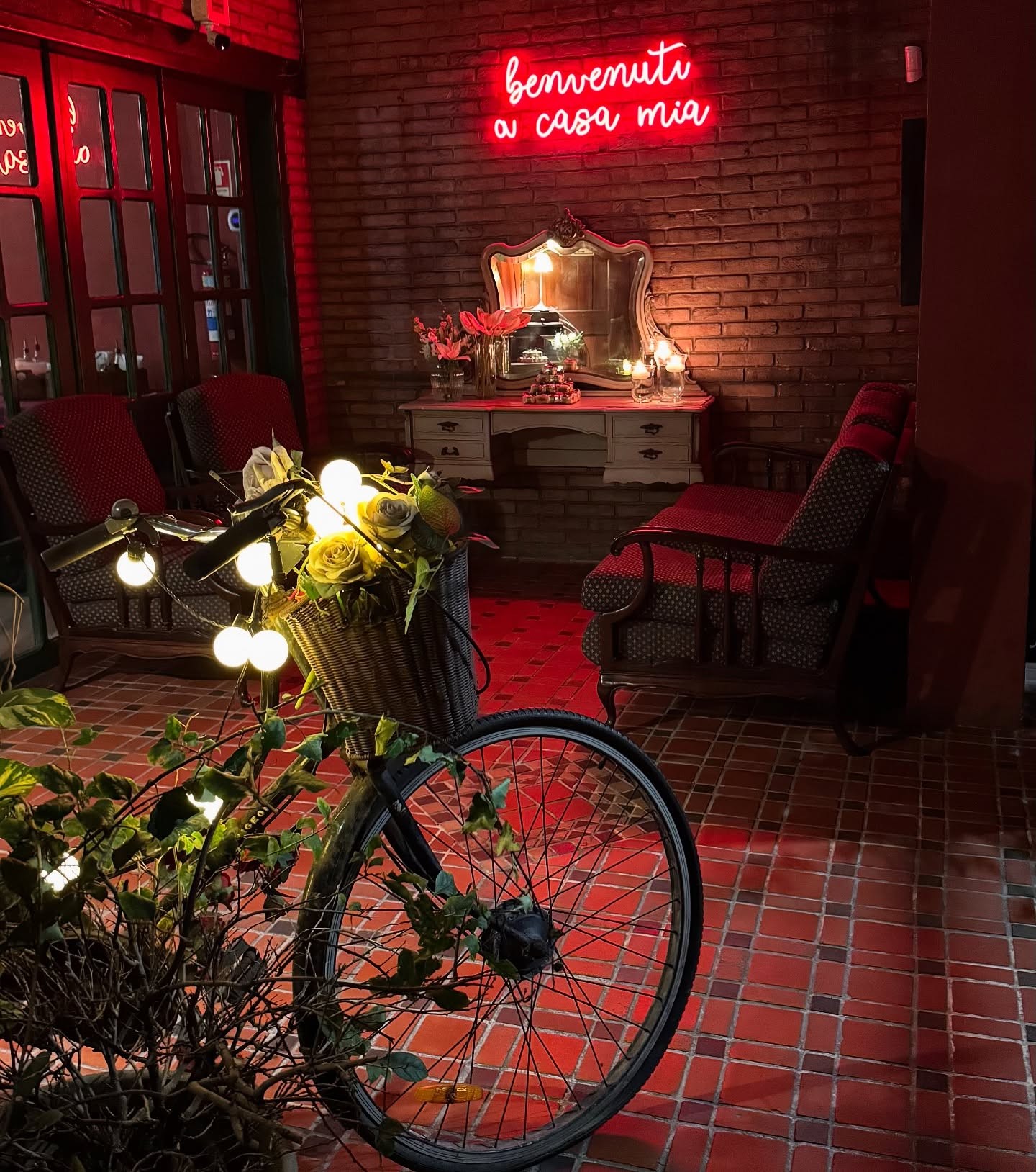 A couple dances closely, showcasing a flowing green dress, against a soft, blurred background of other guests.