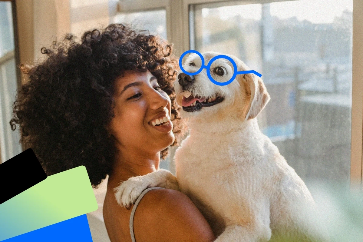 Smiling woman holding her dog while relaxing outdoors in natural light