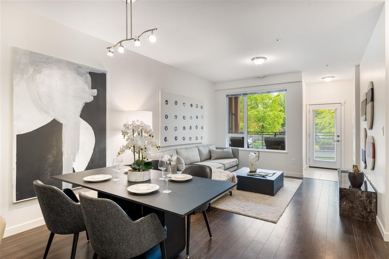 Modern living room with large windows, stylish furniture, and contemporary artwork. Bright and inviting atmosphere.