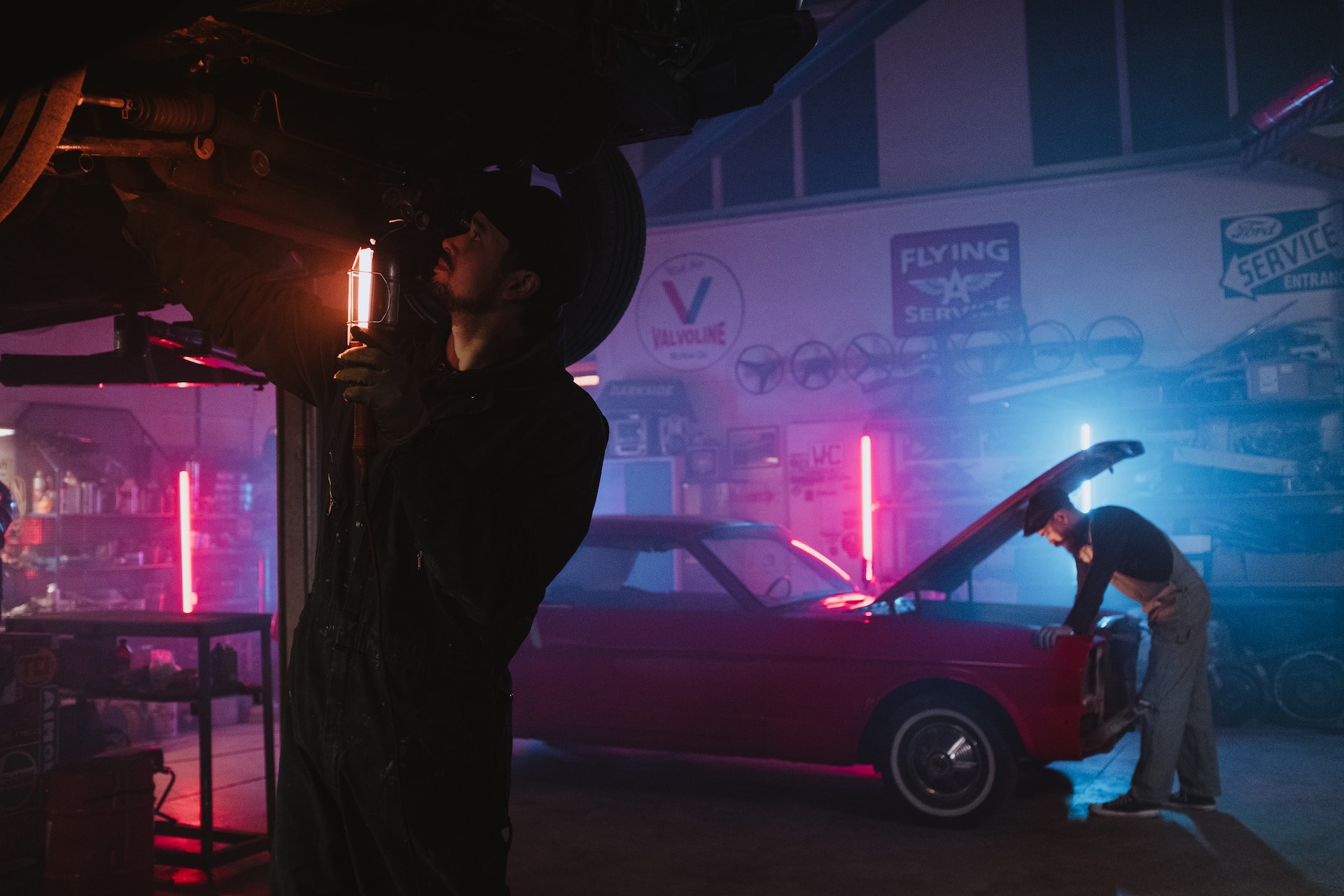 Mechanics working at a Auto Repair Shop. Low light.