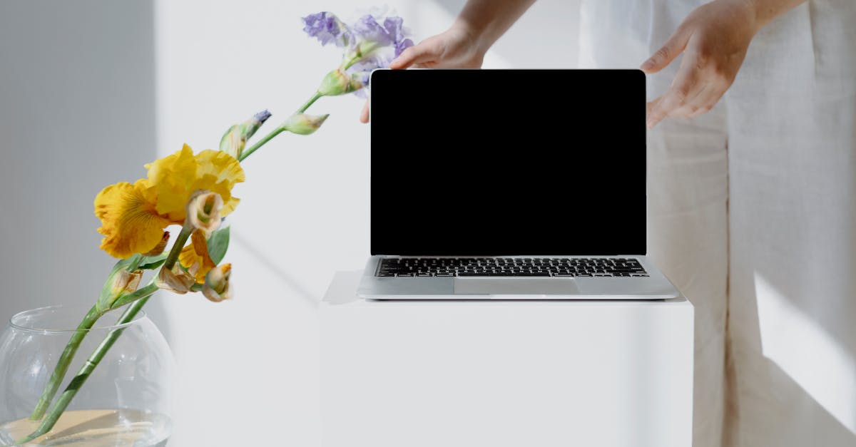 Minimalist workspace featuring a laptop and colorful flowers, perfect for creative inspiration.