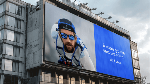 Gold signet ring with engraved emblem resting beside a red wax seal stamped with the same design on a marble surface.
