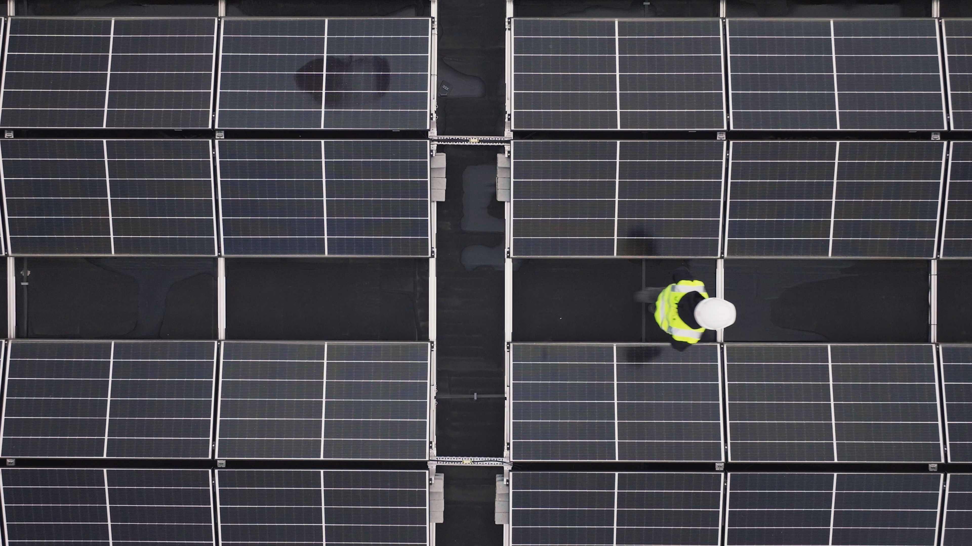 Technicien posant des panneaux solaires sur une toiture résidentielle à Angers