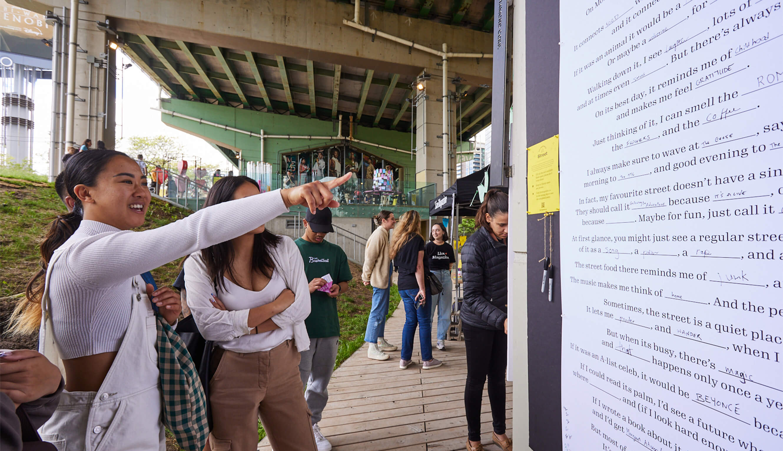 A group of event participants, with one pointing towards a printed poster.