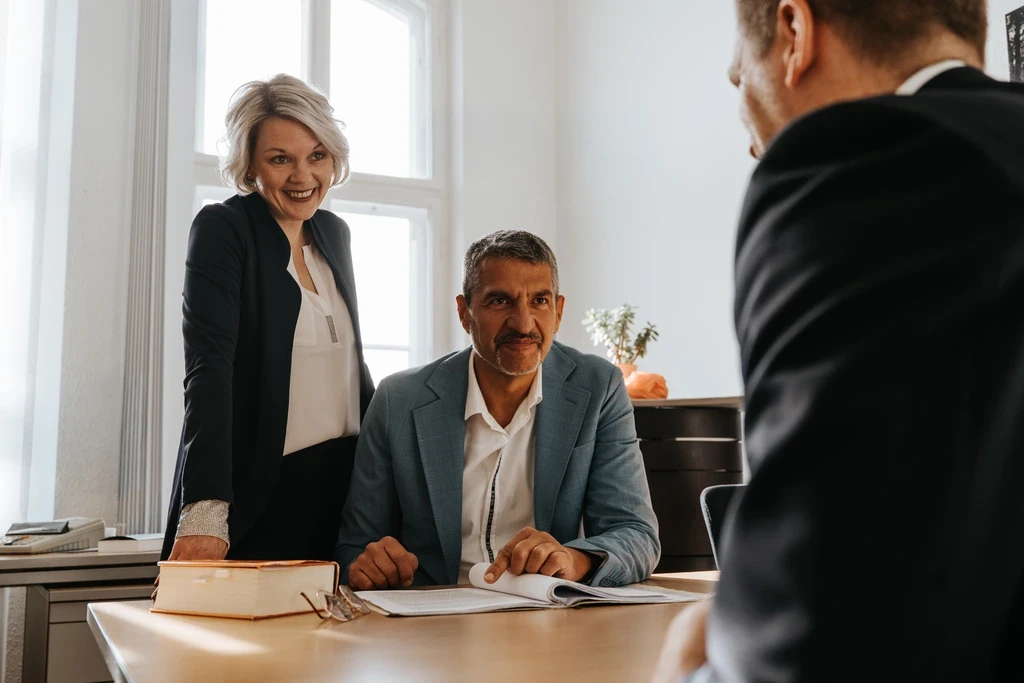 Beratungsgespräch in der Kanzlei Schick & Kollegen: Anwälte im Gespräch mit Mandant am Besprechungstisch.