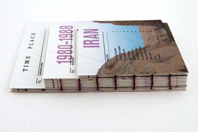 The image shows a book titled "1980-1988 Iran," resting on a white surface. The cover features a photograph of a mountainous landscape with a body of water. The book's spine is white and includes “TIME,” “PLACE,” “03. LANDSCAPES,” “02. VOICES,” and “20. FACTS.” The title “IRAN” is printed in purple on the cover. The book is bound with dark red string or cord along the edges.