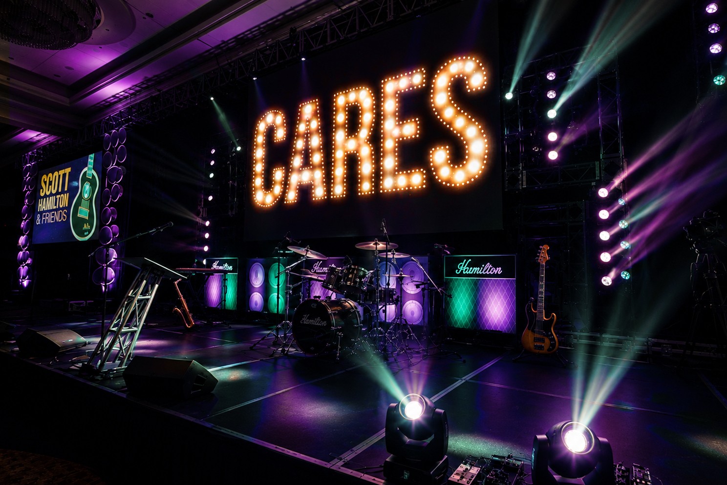 Marquee-bulb 'CARES' letters and concert stage with Hamilton amp props at Omni Nashville — KISS-inspired event production by UpLight Technologies